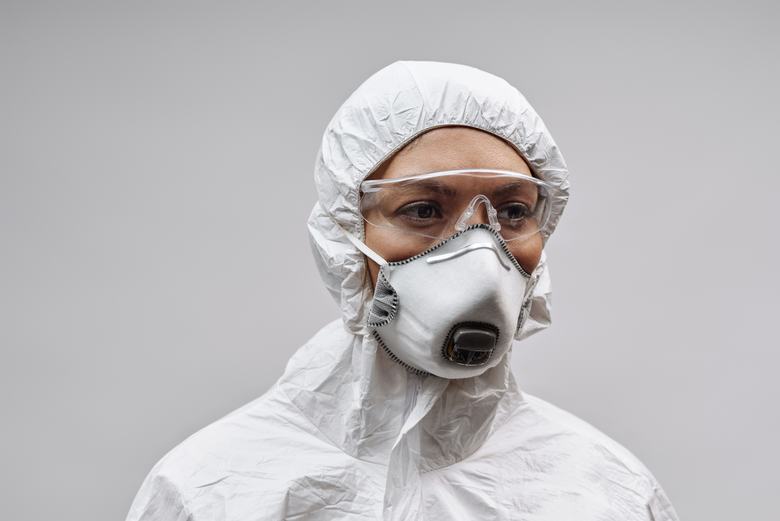 Opérateur en combinaison blanche et masque de protection
